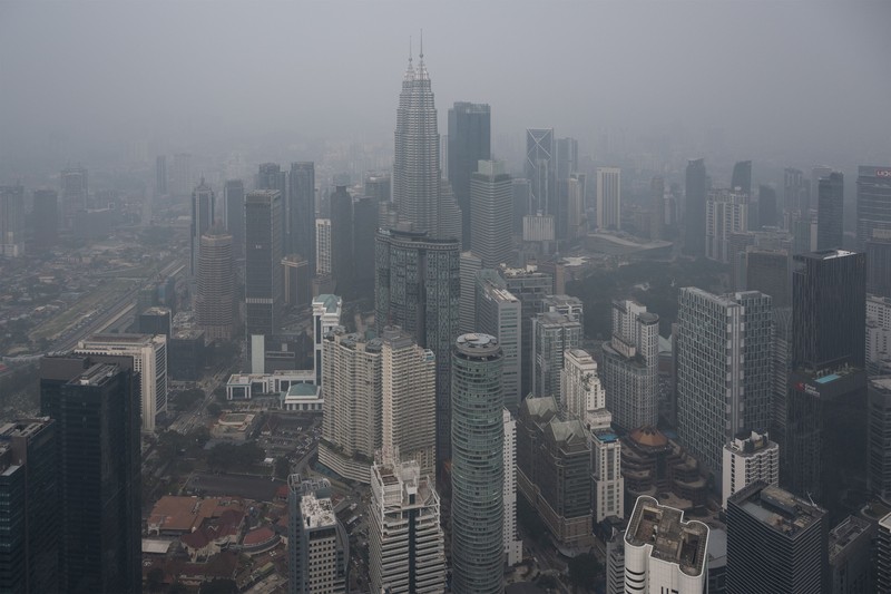 Gedung-gedung komersial terlihat diselimuti kabut di Kuala Lumpur, Malaysia, Selasa (13/10/2026). (Mohd Rasfan / AFP)