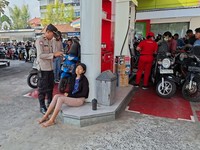Polisi membantu mengamankan pengendara yang pingsan saat antre mengisi BBM di SPBU Latu Abiansemal, Badung, Selasa (13/10/2026). (Dok. Polsek Abiansemal via Detikcom)