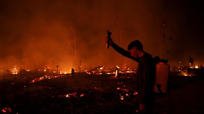 Seorang pemuda menyaksikan hutan hujan Amazon yang telah digunduli terbakar selama musim kemarau di wilayah Autazes, negara bagian Amazonas, Brasil, pada 12 Oktober 2026.