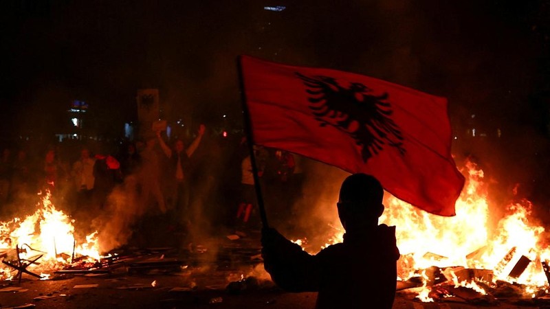 Seorang pengunjuk rasa mengibarkan bendera nasional Albania saat para mahasiswa Albania menggelar unjuk rasa anti-pemerintah di Tirana, Albania, pada 13 Oktober 2026.