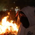 Seorang pria menyaksikan para mahasiswa Albania menggelar unjuk rasa anti-pemerintah di Tirana, Albania, pada 13 Oktober 2026. (REUTERS/Florion Goga)