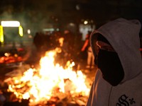 Seorang pria menyaksikan para mahasiswa Albania menggelar unjuk rasa anti-pemerintah di Tirana, Albania, pada 13 Oktober 2026. (REUTERS/Florion Goga)