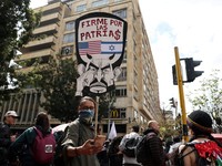 A demonstrator holds a placard reading "Steadfast for the homelands", bearing the flags of the United States and Israel, and depicting Colombian President Abelardo de la Espriella, during a nationwide protest against his government and its proposed l