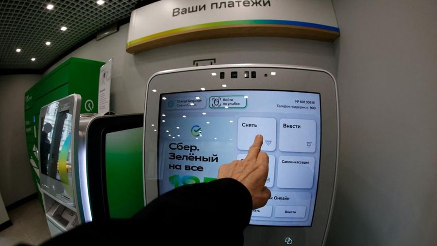 A person uses a cash machine (ATM) at an office of the Russian state-owned lender Sberbank in Moscow on October 14, 2026. A drone hit a data centre belonging to the Russian state-owned lender Sberbank, a company executive said on October 14, 2026, th