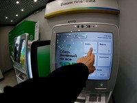 A person uses a cash machine (ATM) at an office of the Russian state-owned lender Sberbank in Moscow on October 14, 2026. A drone hit a data centre belonging to the Russian state-owned lender Sberbank, a company executive said on October 14, 2026, th