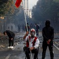 Seorang pria yang mengenakan pakaian menyerupai busana tradisional Albania duduk di tengah puing-puing yang berserakan saat berlangsungnya aksi protes anti-pemerintah oleh para mahasiswa di Tirana, Albania, pada 14 Oktober 2026. (REUTERS/Florion Goga
