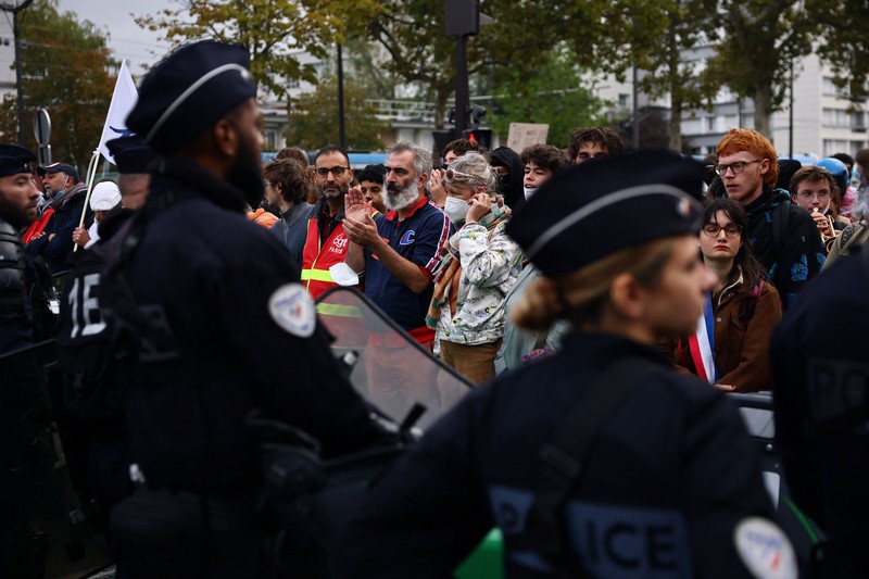 Para siswa sekolah menengah di Prancis berhadapan dengan polisi antihuru-hara CRS saat melakukan aksi duduk untuk memblokir jalan di dekat SMA Lycee Helene-Boucher di Paris. Aksi ini merupakan bagian dari gerakan protes yang terus berlangsung, yang menuntut perbaikan kondisi sekolah serta tindakan dari pemerintah, di Prancis, pada 16 Oktober 2026. (REUTERS/Sarah Meyssonnier)