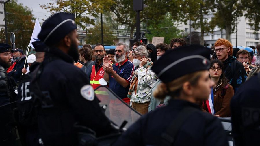 Para siswa sekolah menengah, orang tua, dan guru di Prancis membentuk rantai manusia sambil berhadapan dengan polisi antihuru-hara CRS saat memblokir jalan di dekat sekolah menengah Lycée Hélène-Boucher di Paris. Aksi ini merupakan bagian dari gerakan protes yang terus berlangsung, yang menuntut perbaikan kondisi sekolah serta tindakan nyata dari pemerintah, di Prancis, 16 Oktober 2026.