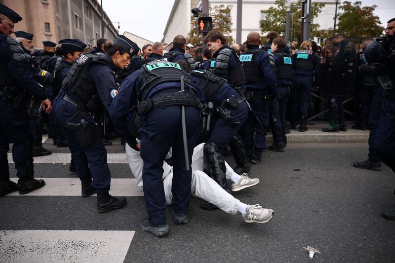 Para siswa sekolah menengah di Prancis berhadapan dengan polisi antihuru-hara CRS saat melakukan aksi duduk untuk memblokir jalan di dekat SMA Lycee Helene-Boucher di Paris. Aksi ini merupakan bagian dari gerakan protes yang terus berlangsung, yang menuntut perbaikan kondisi sekolah serta tindakan dari pemerintah, di Prancis, pada 16 Oktober 2026. (REUTERS/Sarah Meyssonnier)