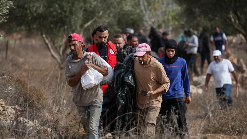 Warga Palestina berjalan di tengah bentrokan dengan para pemukim Israel saat musim panen zaitun, di Abu Falah dekat Ramallah di Tepi Barat yang diduduki Israel, 16 Oktober 2026.