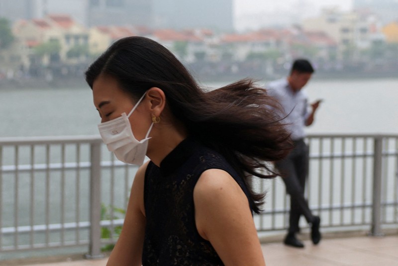 Orang-orang mengenakan masker saat kabut asap menyelimuti Singapura, Jumat (16/10/2026). (REUTERS/Edgar Su)