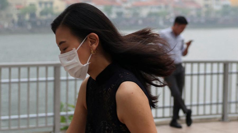 Orang-orang mengenakan masker saat kabut asap menyelimuti Singapura, Jumat (16/10/2026). (REUTERS/Edgar Su)