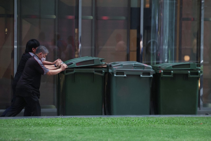 Orang-orang mengenakan masker saat kabut asap menyelimuti Singapura, Jumat (16/10/2026). (REUTERS/Edgar Su)