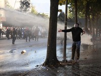A protester gestures, while police use a water canon, as Albanian students hold an anti-government protest in Tirana, Albania, October 19, 2026. REUTERS/Louisa Gouliamaki