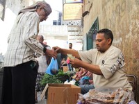 Seorang pedagang kaki lima asal Yaman melayani pelanggan di sebuah pasar di Taiz, Yaman, pada 16 Oktober 2026. (REUTERS/Anees Mahyoub)