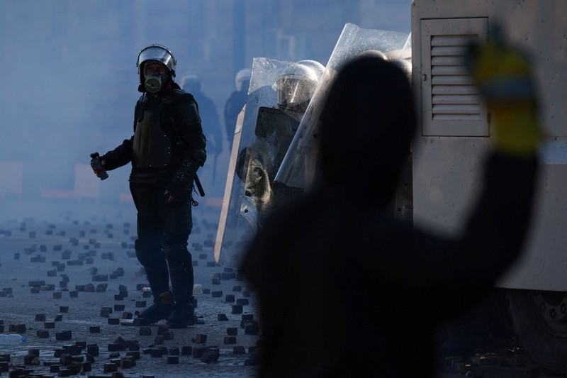 Seseorang mengangkat lengannya di tengah kerusuhan sipil, sehari setelah hari demonstrasi nasional menentang biaya hidup dan kenaikan harga bahan bakar, di Paris, Prancis, 18 Oktober 2026. (REUTERS/Abdul Saboor)
