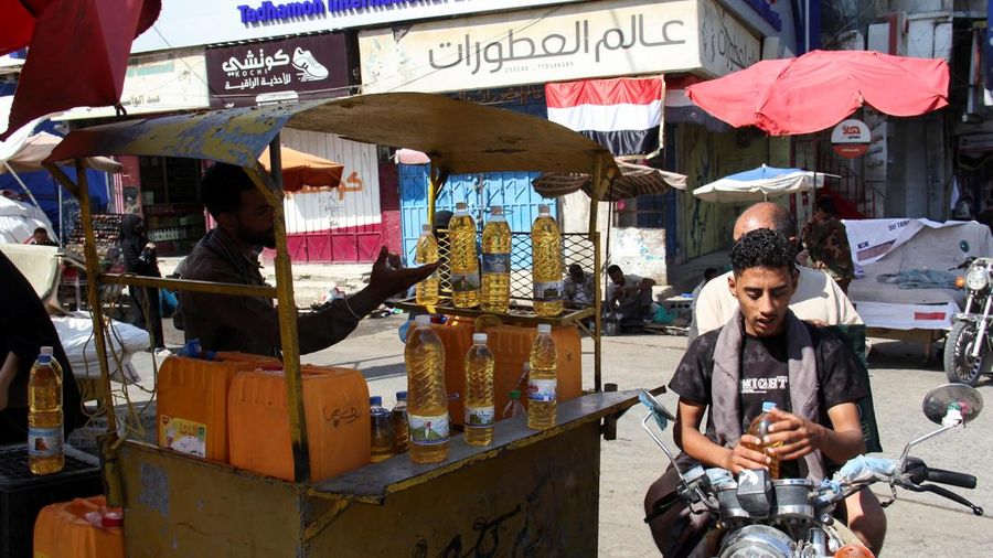 Seorang pria Yaman dengan sepeda motor berada di samping seorang pedagang kaki lima di sebuah pasar di Taiz, Yaman, 16 Oktober 2026.