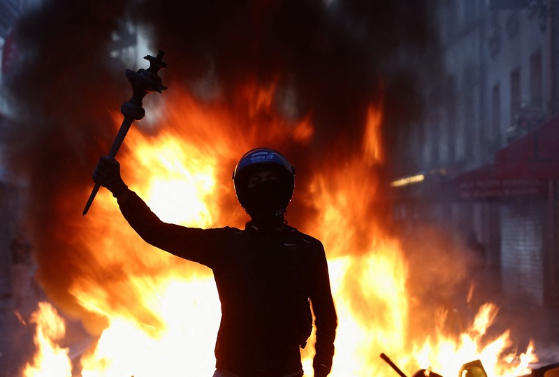Seseorang mengangkat lengannya di tengah kerusuhan sipil, sehari setelah hari demonstrasi nasional menentang biaya hidup dan kenaikan harga bahan bakar, di Paris, Prancis, 18 Oktober 2026. (REUTERS/Abdul Saboor)