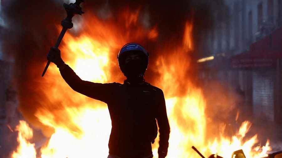 Seseorang mengangkat lengannya di tengah kerusuhan sipil, sehari setelah hari demonstrasi nasional menentang biaya hidup dan kenaikan harga bahan bakar, di Paris, Prancis, 18 Oktober 2026. (REUTERS/Abdul Saboor)