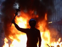 Seseorang mengangkat lengannya di tengah kerusuhan sipil, sehari setelah hari demonstrasi nasional menentang biaya hidup dan kenaikan harga bahan bakar, di Paris, Prancis, 18 Oktober 2026. (REUTERS/Abdul Saboor)