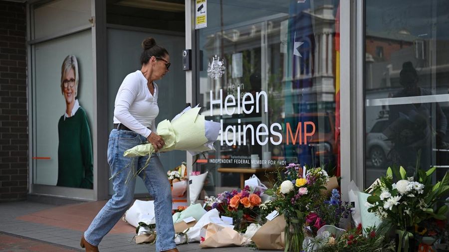A woman leaves flowers outside the electoral office of independent Australian lawmaker Helen Haines, who was deliberately struck by a car outside her office on Monday, in Wangaratta, Australia, October 20, 2026.    AAP/James Ross via REUTERS    ATTEN