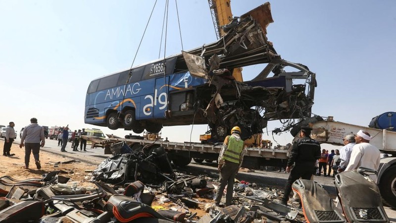 A crane lifts the wreckage of a tour bus following a crash on the desert highway in Giza on October 20, 2026. A large truck crashed into a tour bus west of the Egyptian capital on October 20, killing 13 people and injuring 34, state media reported. (