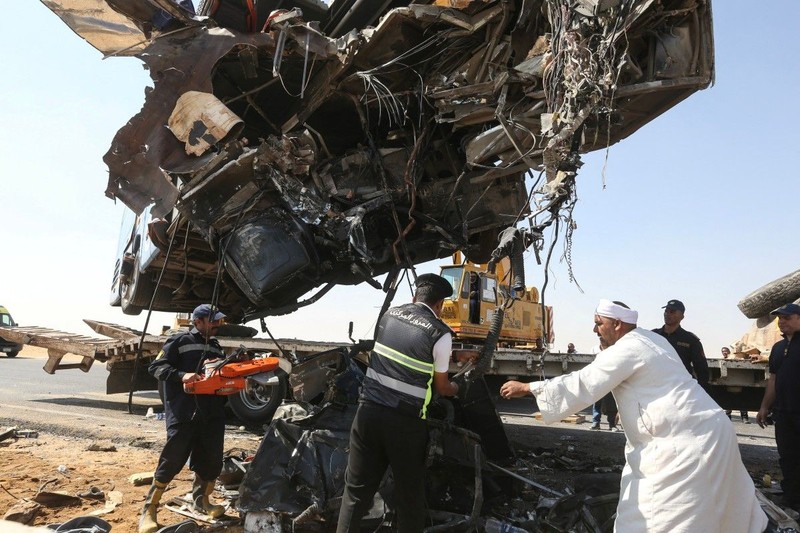 A crane lifts the wreckage of a tour bus following a crash on the desert highway in Giza on October 20, 2026. A large truck crashed into a tour bus west of the Egyptian capital on October 20, killing 13 people and injuring 34, state media reported. (Photo by Khaled KAMEL / AFP)