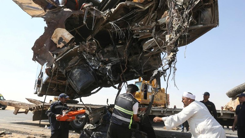 A crane lifts the wreckage of a tour bus following a crash on the desert highway in Giza on October 20, 2026. A large truck crashed into a tour bus west of the Egyptian capital on October 20, killing 13 people and injuring 34, state media reported. (