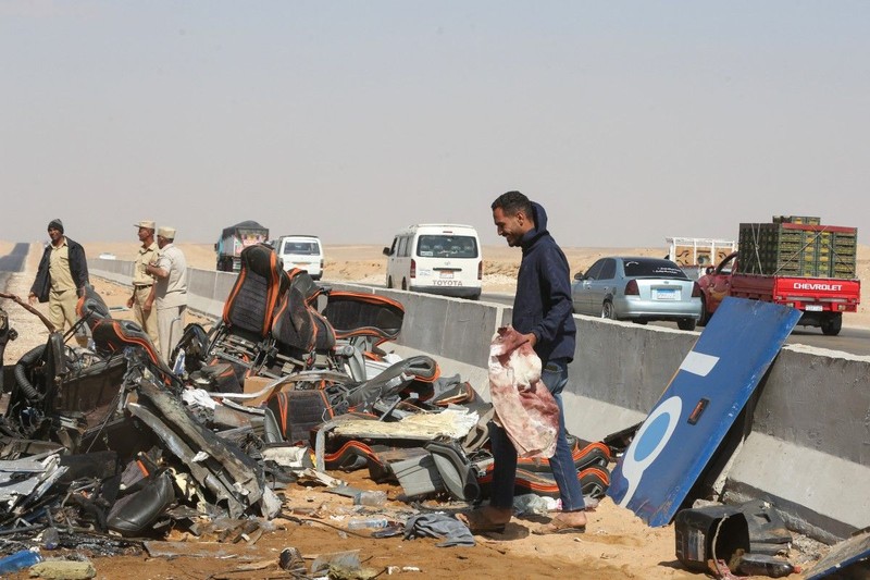 A crane lifts the wreckage of a tour bus following a crash on the desert highway in Giza on October 20, 2026. A large truck crashed into a tour bus west of the Egyptian capital on October 20, killing 13 people and injuring 34, state media reported. (Photo by Khaled KAMEL / AFP)