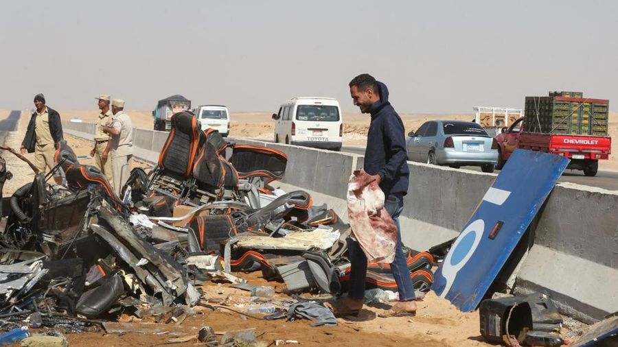 A crane lifts the wreckage of a tour bus following a crash on the desert highway in Giza on October 20, 2026. A large truck crashed into a tour bus west of the Egyptian capital on October 20, killing 13 people and injuring 34, state media reported.