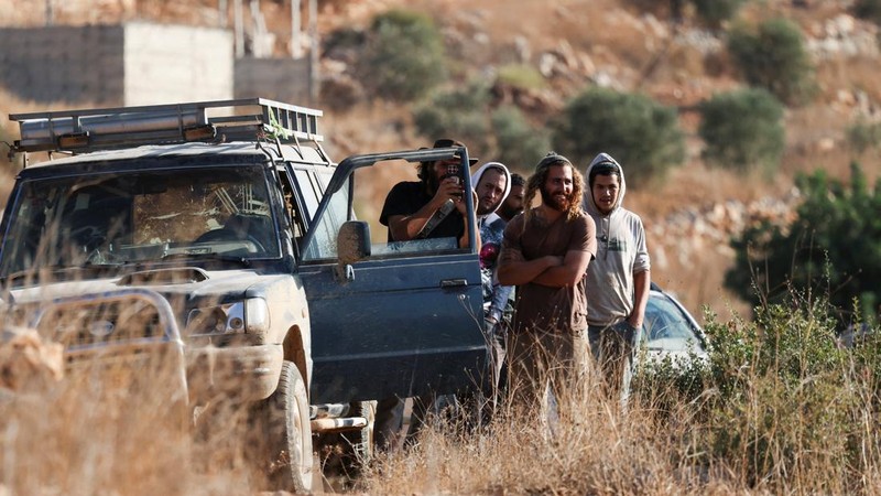 Para pemukim Israel berkumpul saat panen zaitun di kebun zaitun milik warga Palestina di Deir Abu Mashal, dekat Ramallah, di Tepi Barat yang diduduki Israel, pada 19 Oktober 2026. (REUTERS/Ammar Awad)