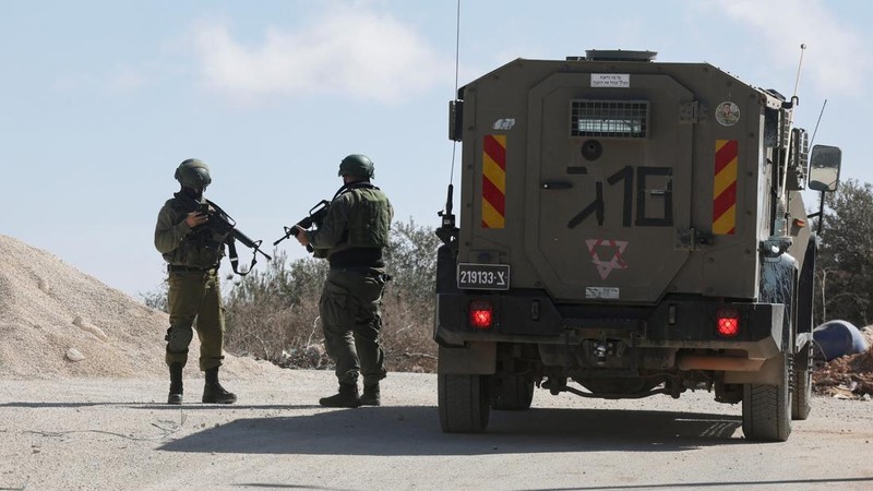 Pasukan Israel berdiri di luar rumah seorang perempuan Palestina, Hanan Hameail, yang rusak akibat serangan pemukim Israel, di Turmus Ayya, Tepi Barat yang diduduki Israel, pada 19 Oktober 2026.