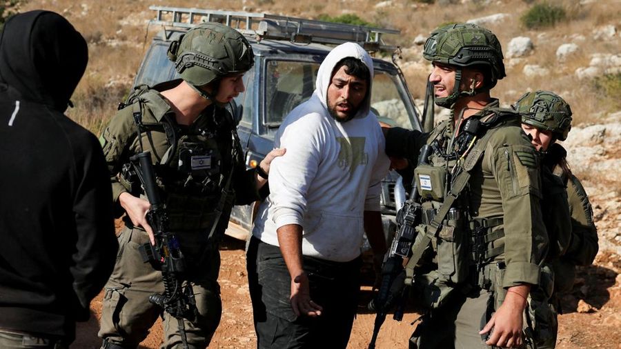 Pasukan Israel menahan seorang pria Palestina saat panen zaitun di kebun zaitun milik warga Palestina di Deir Abu Mashal, dekat Ramallah, di Tepi Barat yang diduduki Israel, pada 19 Oktober 2026.
