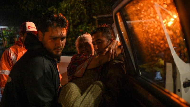 Petugas Perlindungan Sipil mengevakuasi seorang wanita lanjut usia melewati genangan banjir akibat hujan deras yang dipicu oleh Front Dingin Nomor 2 di Coatzacoalcos, negara bagian Veracruz, Meksiko, pada 19 Oktober 2026.