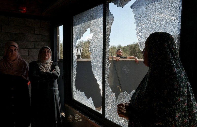 Para pemukim Israel berkumpul saat panen zaitun di kebun zaitun milik warga Palestina di Deir Abu Mashal, dekat Ramallah, di Tepi Barat yang diduduki Israel, pada 19 Oktober 2026. (REUTERS/Ammar Awad)