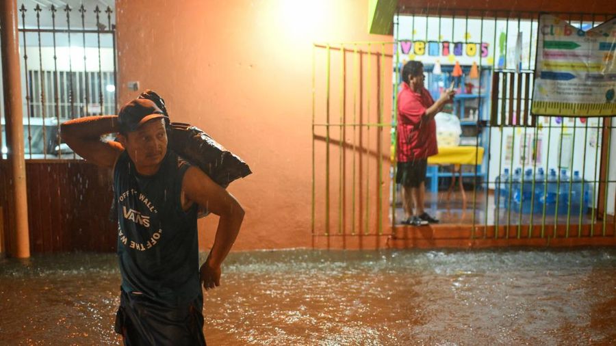Seorang pria berdiri di tengah genangan banjir di sebuah jalan setelah hujan deras yang dipicu oleh Front Dingin Nomor 2 di Coatzacoalcos, negara bagian Veracruz, Meksiko, pada 19 Oktober 2026.
