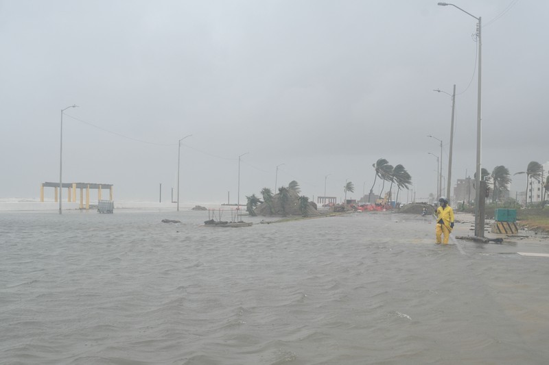 Warga mengarungi genangan banjir di sebuah jalan setelah hujan deras yang dipicu oleh Front Dingin Nomor 2 di Coatzacoalcos, negara bagian Veracruz, Meksiko, pada 19 Oktober 2026. (REUTERS/Angel Hernandez)