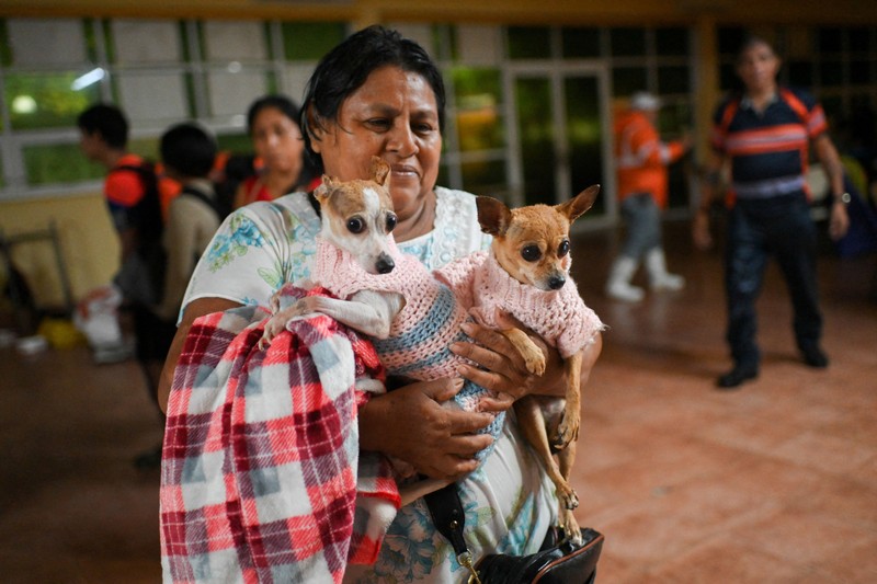 Warga mengarungi genangan banjir di sebuah jalan setelah hujan deras yang dipicu oleh Front Dingin Nomor 2 di Coatzacoalcos, negara bagian Veracruz, Meksiko, pada 19 Oktober 2026. (REUTERS/Angel Hernandez)