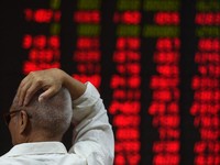 An investor watches stock price movements at a securities company in Beijing on June 15, 2016. China on June 15 brushed off stock index firm MSCI's decision to exclude the country's A shares from its influential global equities index, saying that the