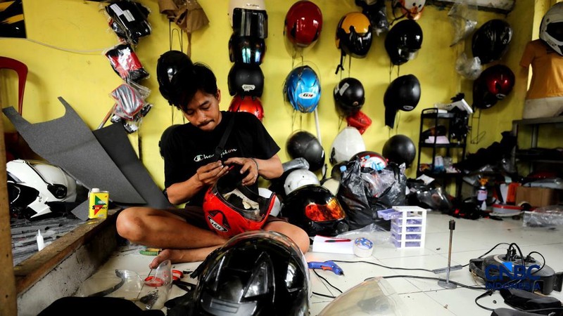 Pekerja melakukan perbaikan helm milik konsumen di salah satu gerai di kawasan Jakarta, Rabu (21/10/2026).