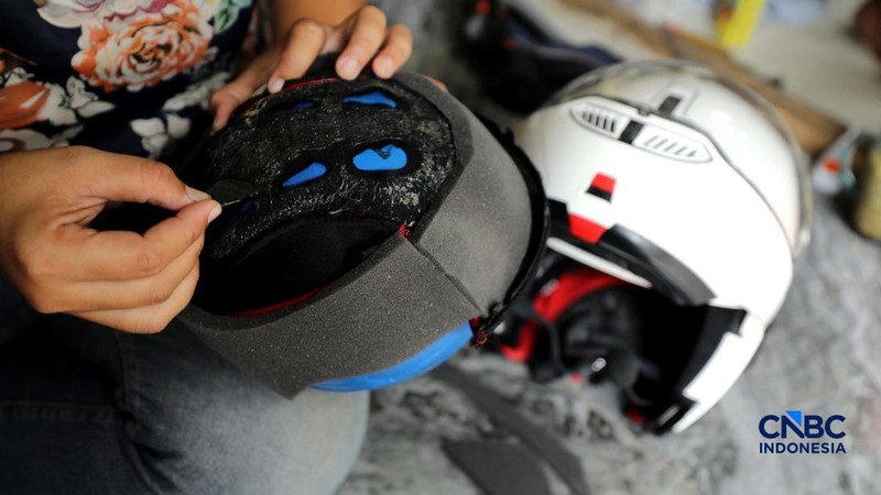 Pekerja melakukan perbaikan helm milik konsumen di salah satu gerai di kawasan Jakarta, Rabu (21/10/2026).