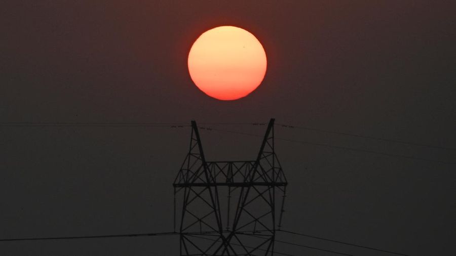 The sun sets next to power lines along San Fernando town, Pampanga province, north of Manila on April 16, 2026. (Photo by Ted ALJIBE / AFP)