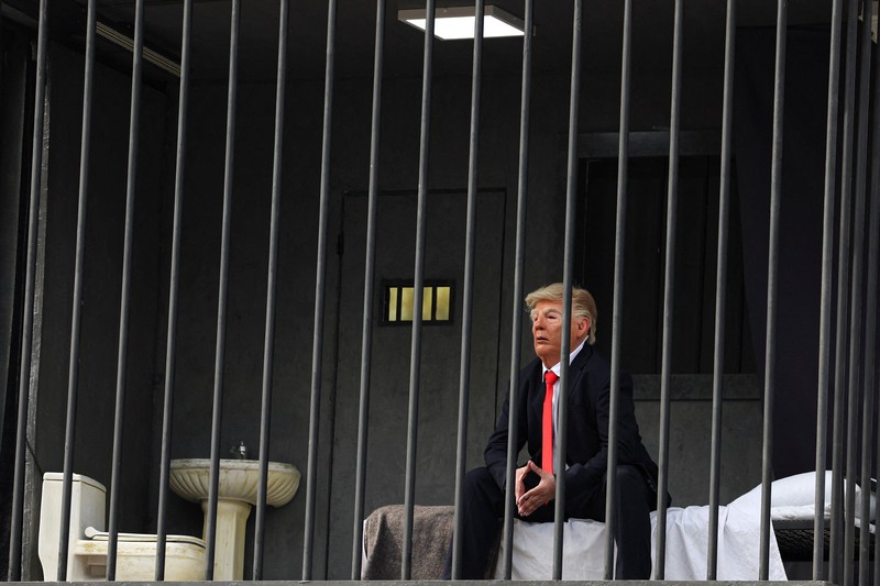 Iran membuat sindiran atau olok-olok terbaru terhadap Presiden Amerika Serikat (AS) Donald Trump, Rabu (21/10/2026). Iran membuat sosok tiruan Trump berada di balik jeruji besi yang dibuat di atas papan reklame. (via REUTERS/Majid Asgaripour)