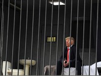 Iran membuat sindiran atau olok-olok terbaru terhadap Presiden Amerika Serikat (AS) Donald Trump, Rabu (21/10/2026). Iran membuat sosok tiruan Trump berada di balik jeruji besi yang dibuat di atas papan reklame. (via REUTERS/Majid Asgaripour)