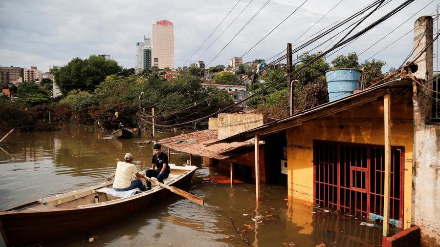 Warga berjalan menggunakan perahu melewati lingkungan nan terendam air setelah hujan deras menyebabkan banjir, di Ciudad del Este, Paraguay, 21 Oktober 2026.