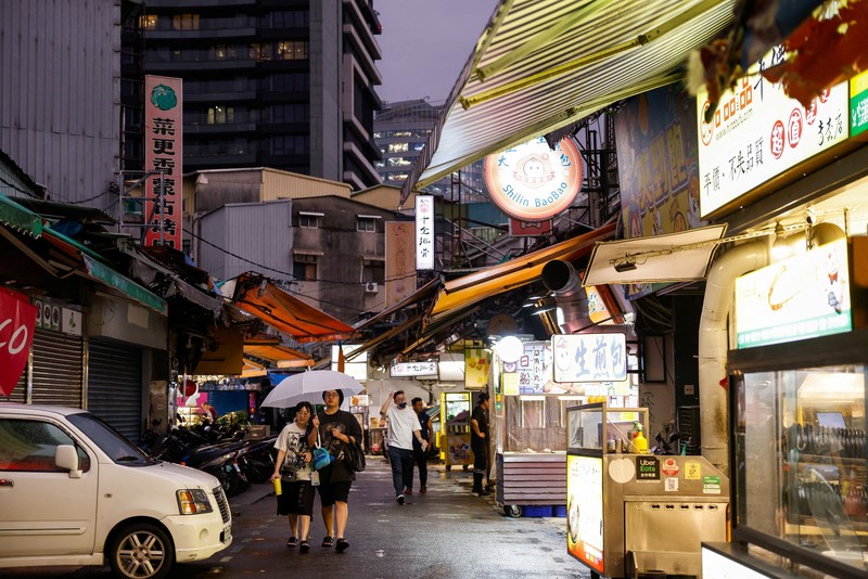 Orang-orang membawa payung di tengah hujan saat Topan Champi mendekat, di Taipei, Taiwan, 22 Oktober 2026. (REUTERS/Ann Wang)