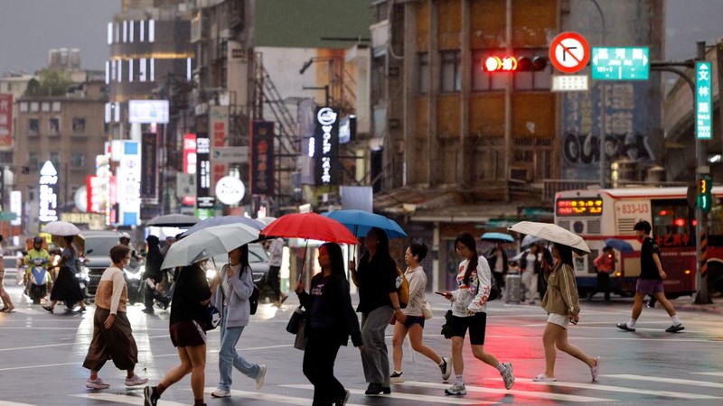 Orang-orang membawa payung di tengah hujan saat Topan Champi mendekat, di Taipei, Taiwan, 22 Oktober 2026. (REUTERS/Ann Wang)