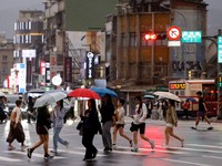 Orang-orang membawa payung di tengah hujan saat Topan Champi mendekat, di Taipei, Taiwan, 22 Oktober 2026. (REUTERS/Ann Wang)