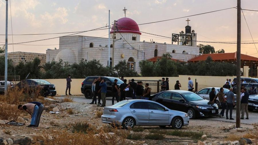 Warga dan pasukan keamanan berkumpul di luar Gereja Ortodoks Yunani di desa Hammoud di provinsi Karak, Yordania, setelah penembakan pada 23 Oktober 2026. (Photo by AFP)