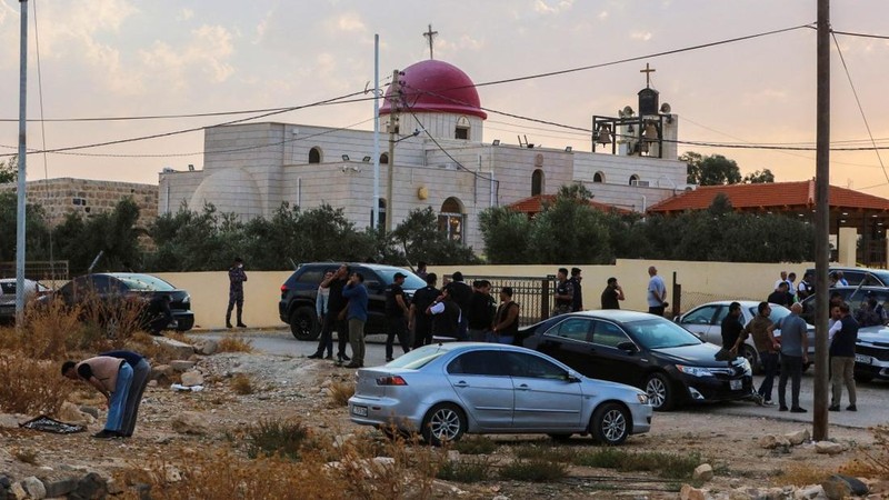 Warga dan pasukan keamanan berkumpul di luar Gereja Ortodoks Yunani di desa Hammoud di provinsi Karak, Yordania, setelah penembakan pada 23 Oktober 2026. (Photo by AFP)
